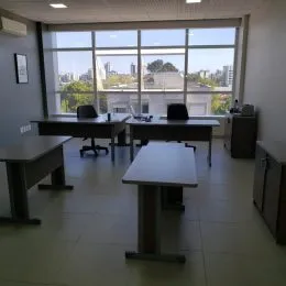 Foto de uma sala de jantar com grandes janelas.