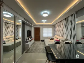 Sala de estar moderna com paredes brancas e detalhes em preto.