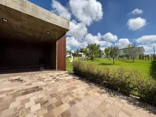 Vista externa de uma propriedade com pátio e jardim.