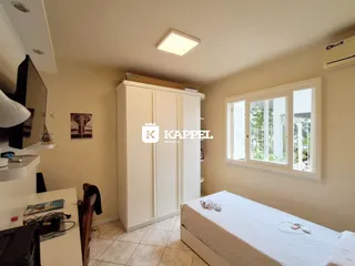 Quarto com cama e guarda-roupa branco em um imóvel.