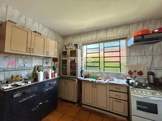 Foto de uma cozinha com armários e bancadas em um imóvel.