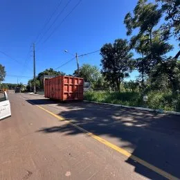 Vista de uma rua asfaltada com vegetação ao lado.
