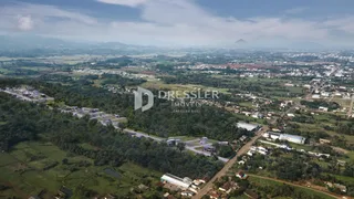 Vista aérea de uma paisagem rural no Brasil com vegetação e estruturas dispersas.
