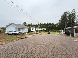 Foto externa da fachada de uma casa em uma área com vegetação ao fundo.