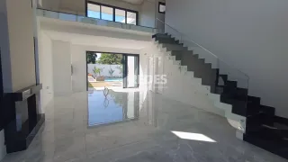 Vista interna de uma área com escadaria e grande abertura para o exterior.