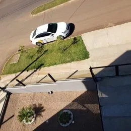 Vista externa mostrando uma área de paisagismo e um caminho de concreto.