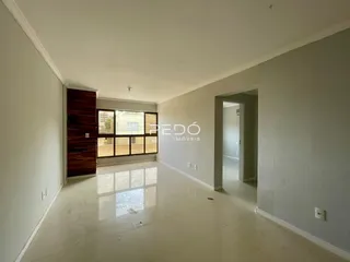 Hall de entrada com piso claro e paredes brancas em um imóvel.
