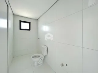 Um banheiro com paredes brancas e piso cerâmico.
