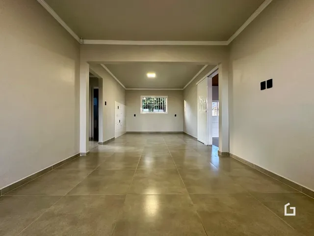 Hall de passagem interno com piso de cerâmica e paredes claras.