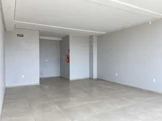 Ambiente interno com piso de cerâmica e paredes brancas em um imóvel.
