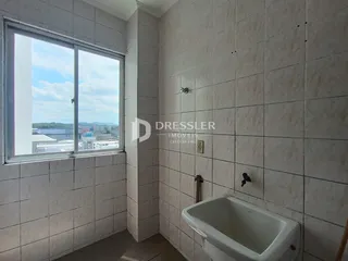 Foto de um banheiro com paredes de azulejo claro e uma janela.