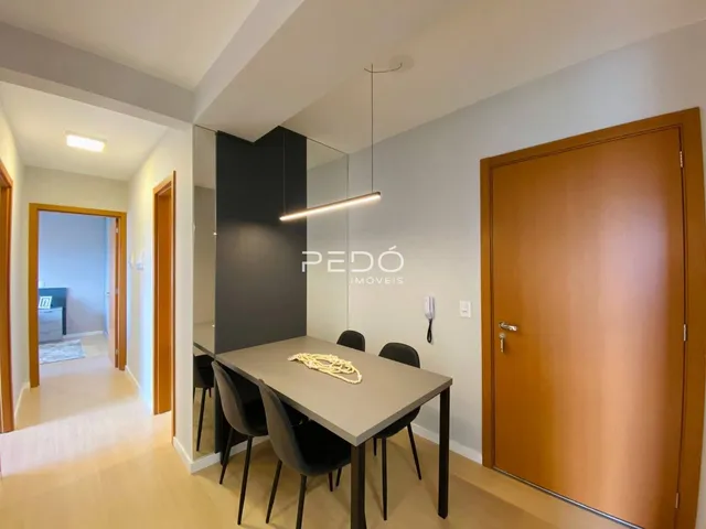 Vista de uma sala de jantar com portas e um espelho em um imóvel em Lajeado.