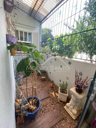 Foto da varanda com vegetação e grade metálica.