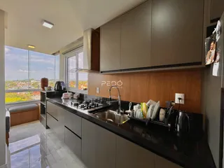 Vista da cozinha moderna com grandes janelas que oferecem uma bela paisagem.