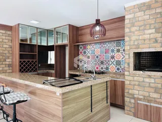 Vista de uma cozinha moderna com armários de madeira e revestimento de azulejos no Brasil.