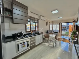 Uma cozinha moderna com armários brancos e piso de cerâmica clara.