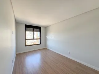 A sala de estar apresenta piso de madeira clara e paredes brancas.