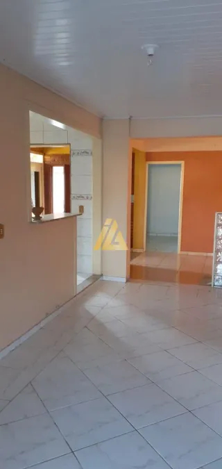 Corredor interno com piso de cerâmica clara e portas brancas.