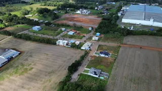 Vista aérea de uma propriedade rural com campos abertos e estruturas dispersas.