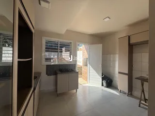 Sala de estar com piso de cerâmica e janela na área interna da residência.