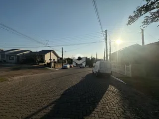 Vista da entrada de uma propriedade em Lajeado, Brasil, com uma estrada pavimentada.