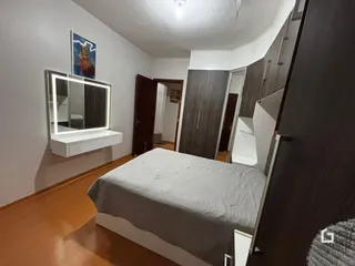 Quarto com cama e armários em ambiente interno.
