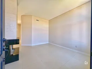 Interior de um espaço com paredes brancas e piso de cerâmica.