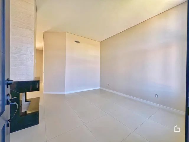 Interior de um espaço com paredes brancas e piso de cerâmica.