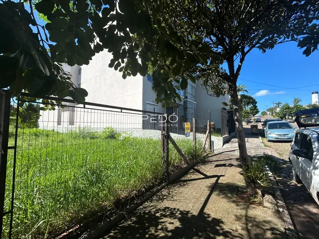 Fachada de uma residência branca com cerca e vegetação no primeiro plano.