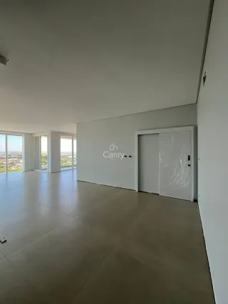 Sala ampla com piso claro e grandes janelas que proporcionam vista.