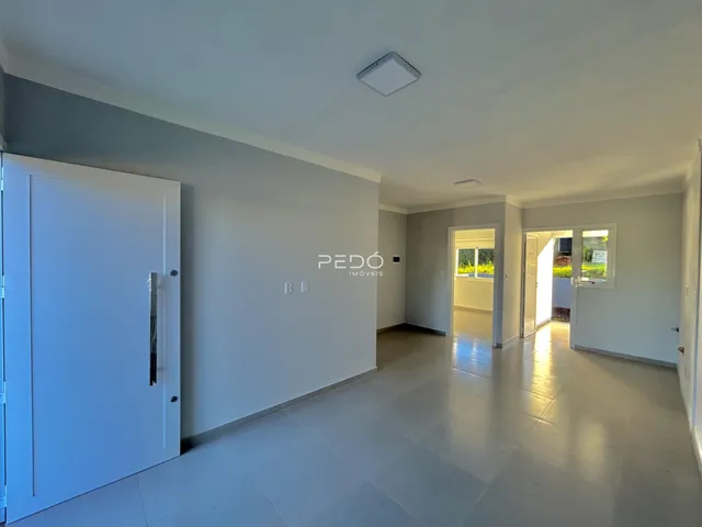 Hall de entrada com piso claro e paredes brancas.