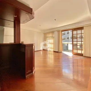 Sala de estar com piso de madeira e portas de vidro grandes.