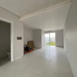 Hall de entrada com paredes brancas e piso claro.