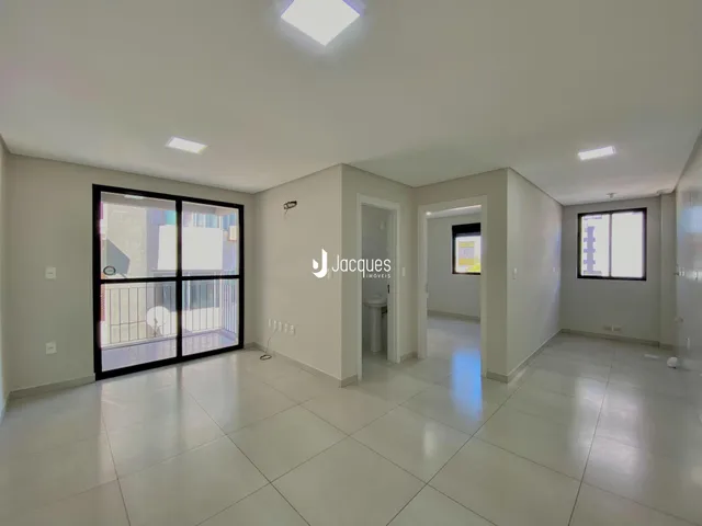 Ambiente interno com porta de vidro abrindo para uma varanda.