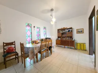 Sala de estar com móveis de madeira e piso de cerâmica clara.