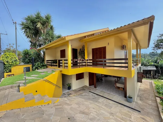 Fachada de uma casa em Lajeado, Brasil, com varanda amarela.