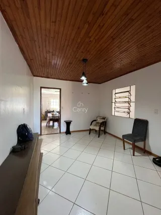 Sala de estar com piso de cerâmica e teto de madeira aparente.