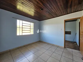 Interior de uma sala com piso de cerâmica e teto de madeira.