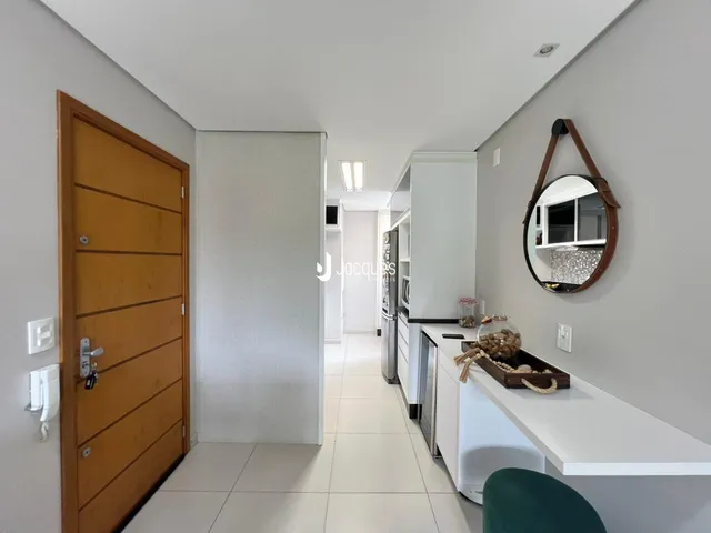 Corredor interno com piso de cerâmica e porta de madeira na residência.