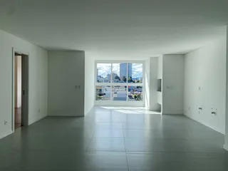 Foto de uma sala ampla com piso de cerâmica e grande janela com vista para a paisagem urbana.