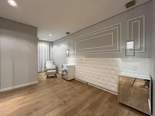 Sala de estar com piso de madeira clara e paredes cinzas na residência.