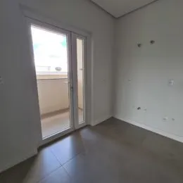 Vista interna de um cômodo com porta de vidro.