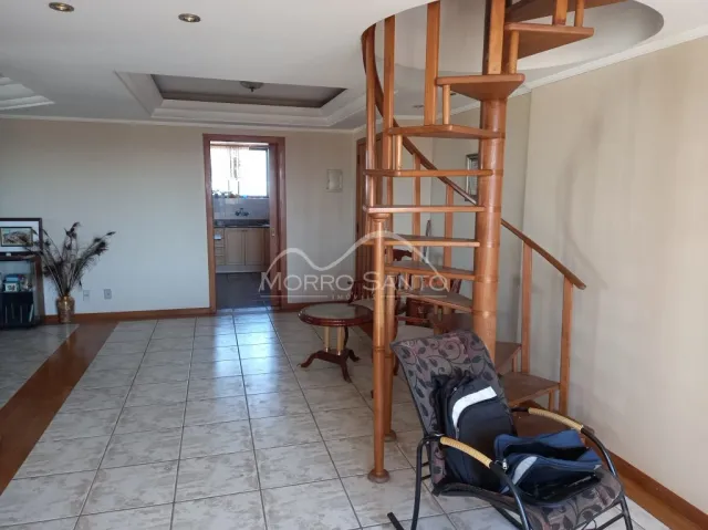 Hall de entrada com piso de cerâmica e escadaria de madeira em um imóvel.