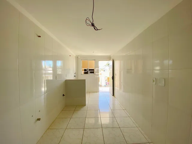 Corredor interno de um imóvel com piso de cerâmica claro.