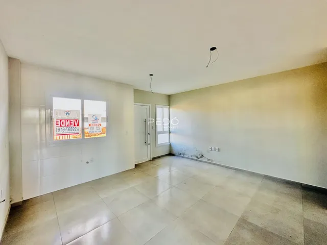 Interior de uma sala com piso de cerâmica e paredes brancas.