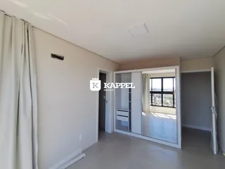 Hall de entrada com paredes brancas e um armário embutido.