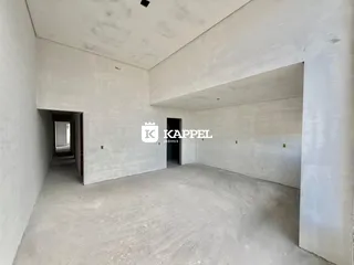 Vista interna de um espaço amplo com piso de concreto aparente.
