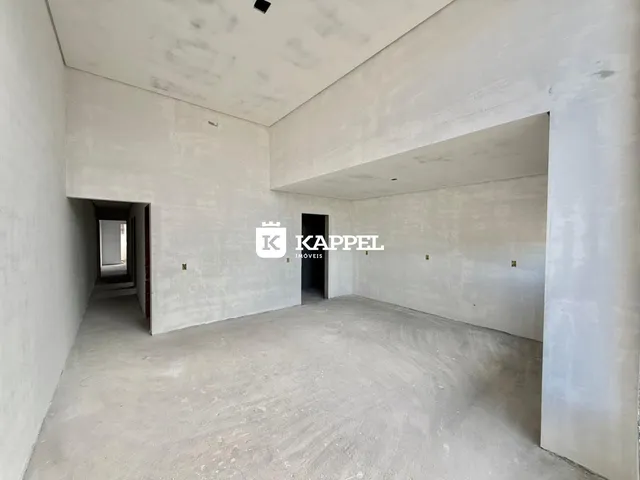 Vista interna de um espaço amplo com piso de concreto aparente.