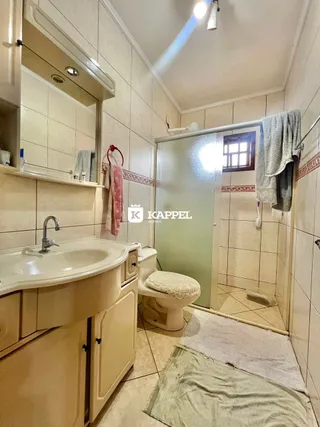 Foto de um banheiro com revestimento de azulejos e bancada de pia.