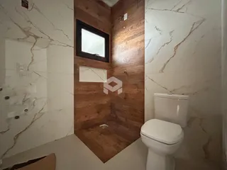 Banheiro com paredes de mármore e piso de madeira.